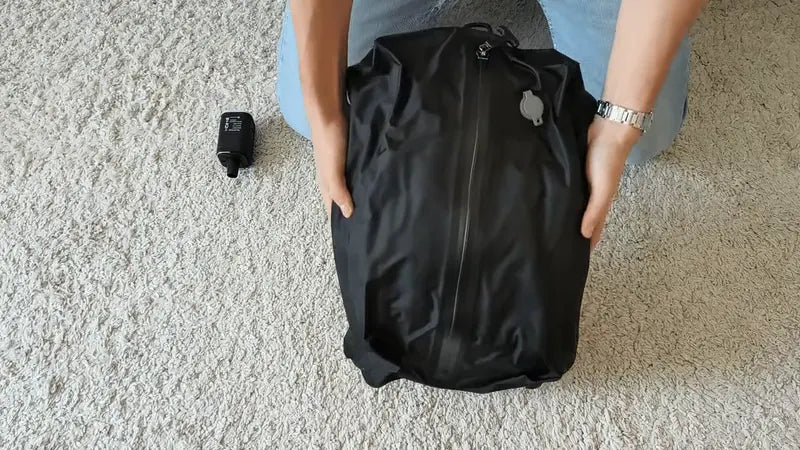 Sac noir compacté et rangé dans une valise ouverte
